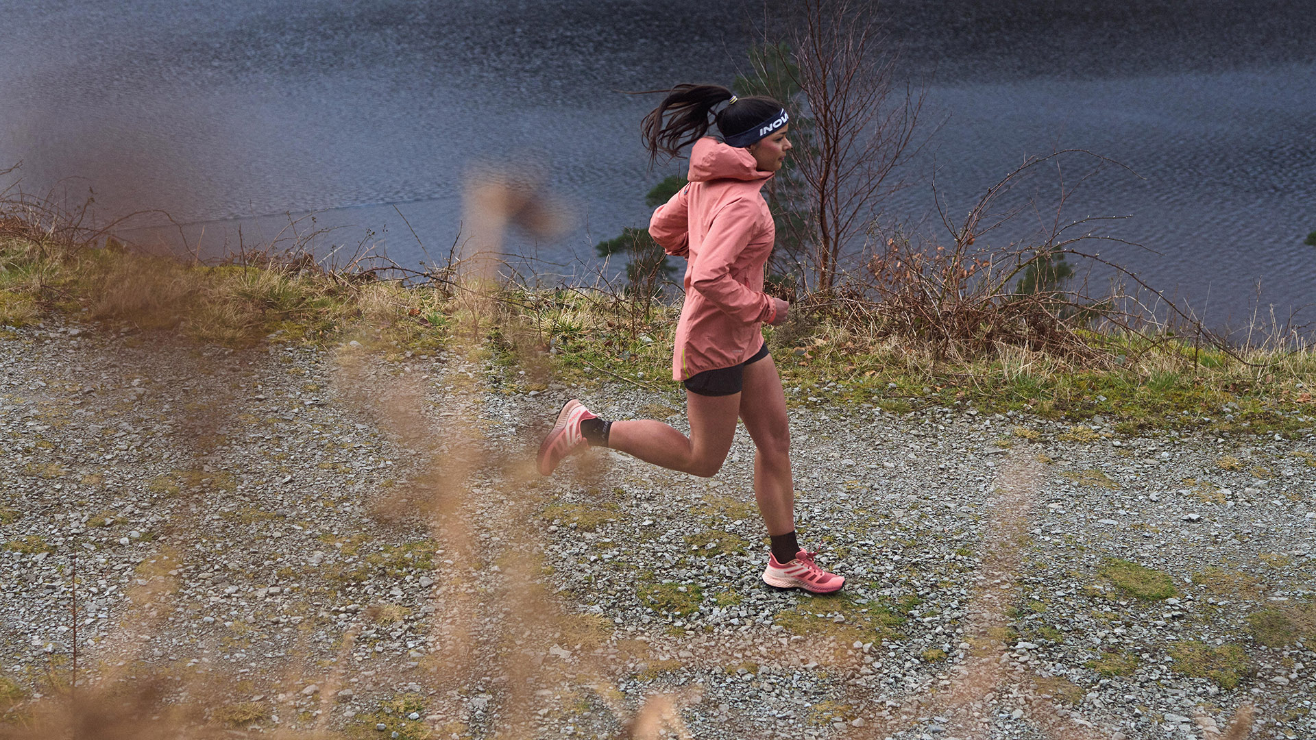Sarah Perry running along a canal path in INOV8 gear