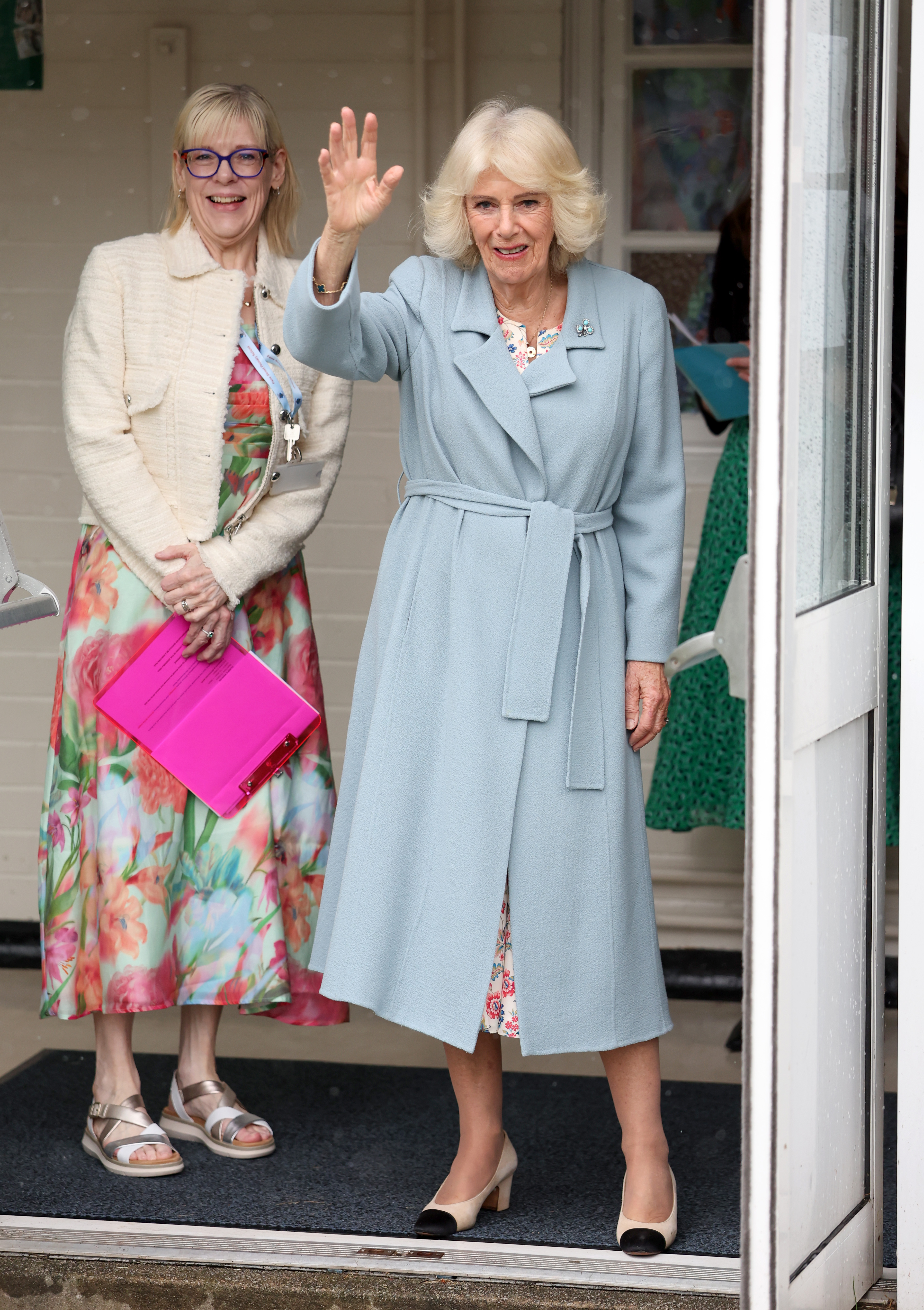 Queen Camilla wearing a blue coat and waving