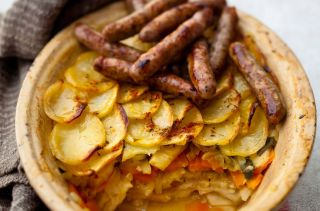 Root vegetable layer bake with sausages on top