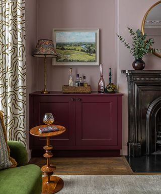 living room with pink walls, purple built in storage and a green couch