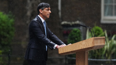 Rishi Sunak stands at a lectern in the rain outside Number 10 Downing Street