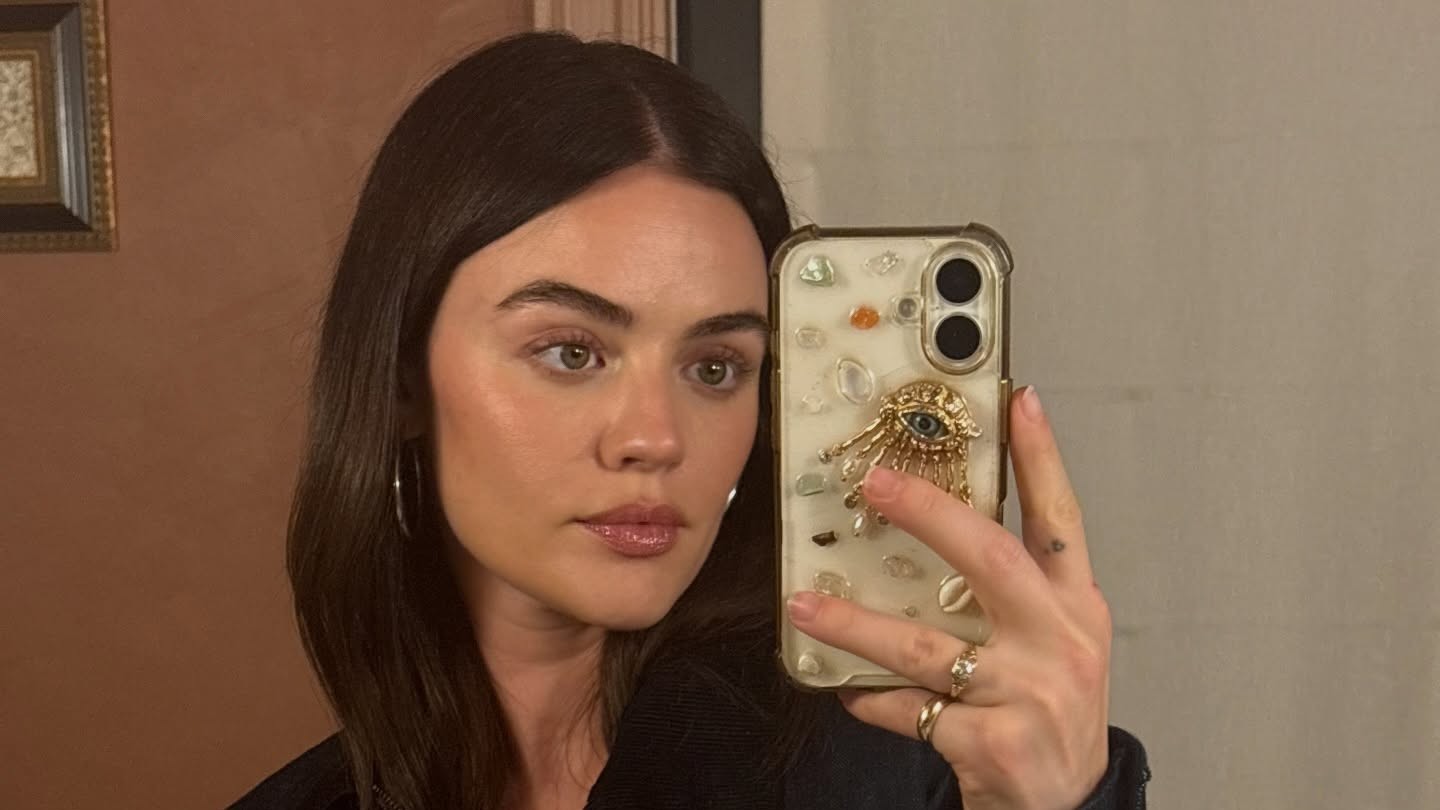 A selfie of Lucy Hale holding a bedazzled phone case