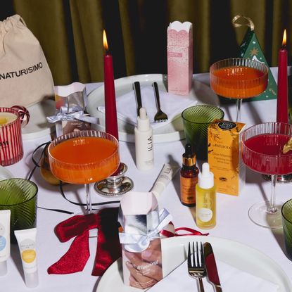 Naturisimo beauty products on a festive table spread with candle sticks and ribbons