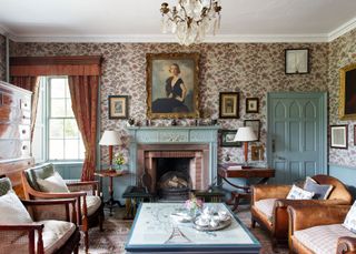 a formal living room with floral wallpaper and eggshell accented doors and fireplace