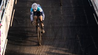 Amy Perryman descending a man made obstacle during a cyclocross race