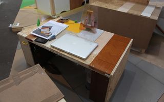 A laptop and books on a wooden desk