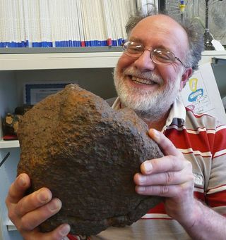 Geochemist Randy Korotev of Washington University in St. Louis holds the meteorite he helped analyze to identify its parent body.