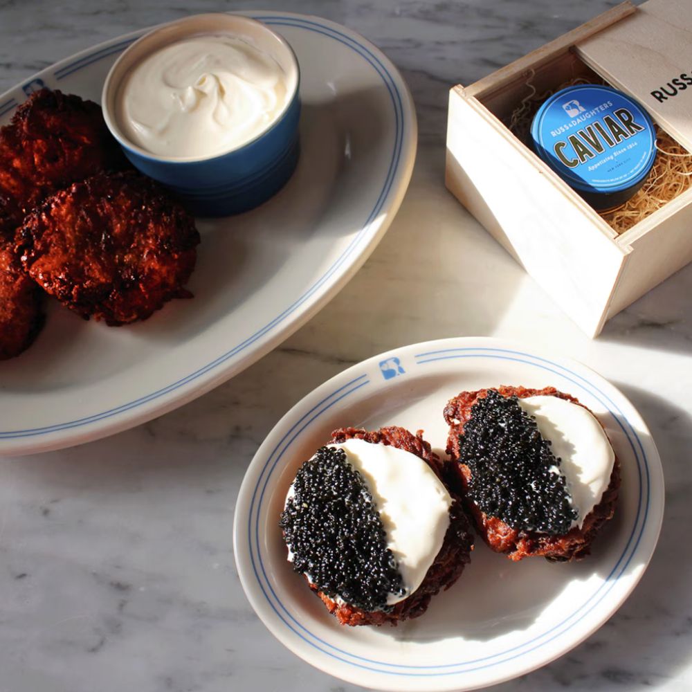 caviar and sour cream on potato cakes on a plate