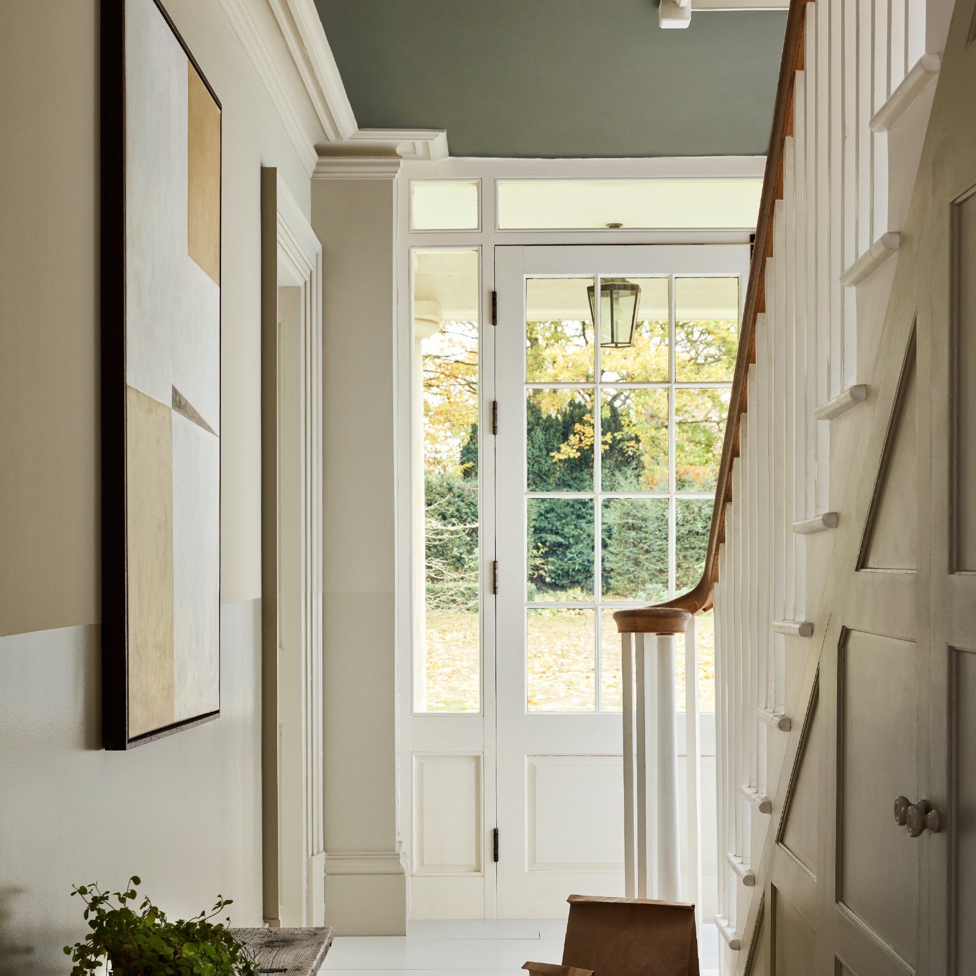 A bright hallway with neutral two-tone painted wall and a green ceiling