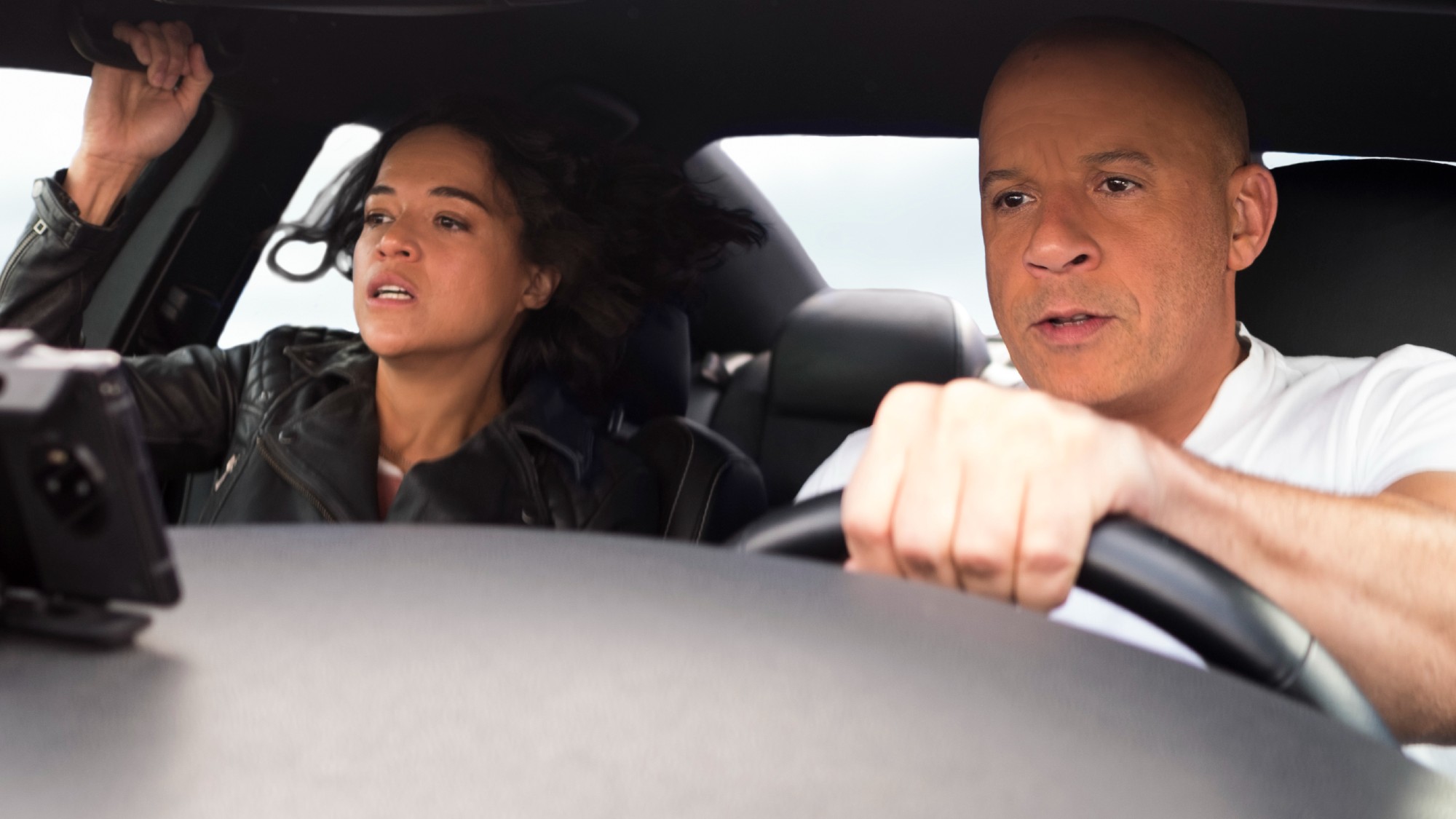 Letty Ortiz (Michelle Rodriguez) and Dominic Toretto (Vin Diesel) ride in a car in F9: The Fast Saga.