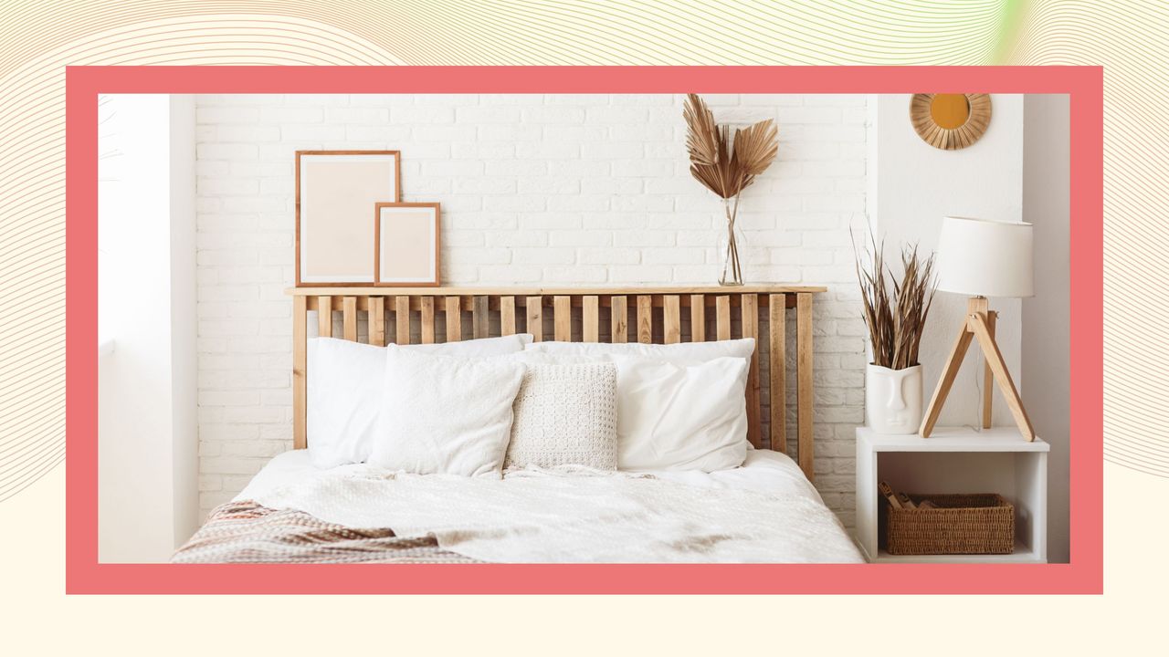 A wooden bed with white bedding on a pink and cream background.