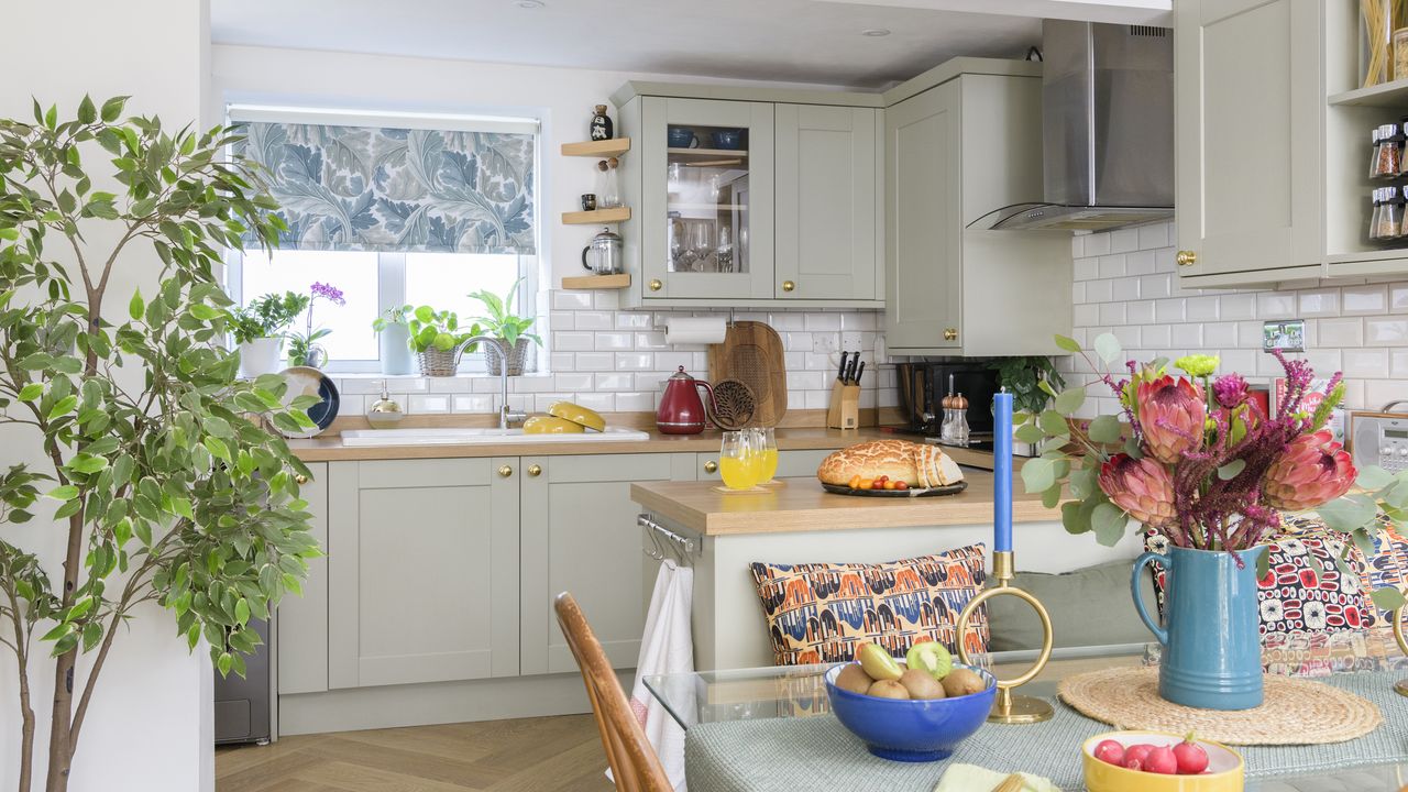 Green shaker kitchen with table in forefront