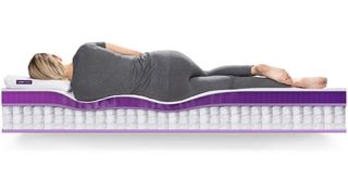 Purple Hybrid mattress review: a photograph showing a woman lying on her side on the Purple Hybrid mattress and how it perfectly adapts to her body