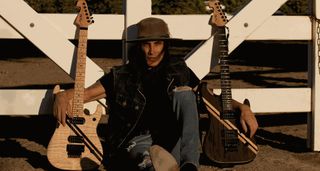 Nuno Bettencourt launches his own guitar company, and poses with his new models against a fence.