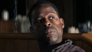 A close up of Sterling K. Brown looking skeptical in Paradise