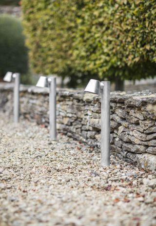 gravel driveway with small lights by garden trading