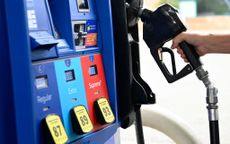 A hand reaches for a gas pump at a station in Virginia in 2022. 