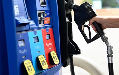 A hand reaches for a gas pump at a station in Virginia in 2022. 