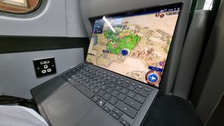 An Asus Zenbook Duo laptop being used to play Civ 6 on a UK train