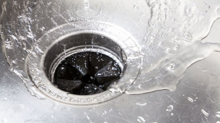Clear water running down a garbage disposal drain