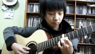 Sungha Jung plays an acoustic guitar