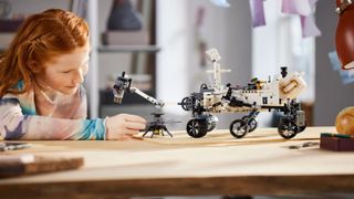 A lifestyle shot of the Lego Technic NASA Mars Rover Perseverance playset being built by a teenage girl.