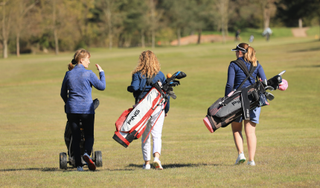 Three female golfers walking