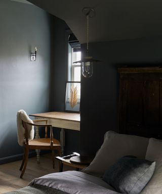 A blue room with a small alcoved desk