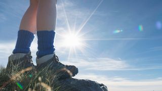 Pair of thick hiking socks in boots standing on rock