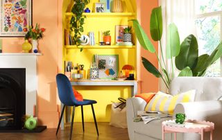 yellow paint alcove with home office set-up in living room with peach painted walls and wooden floor