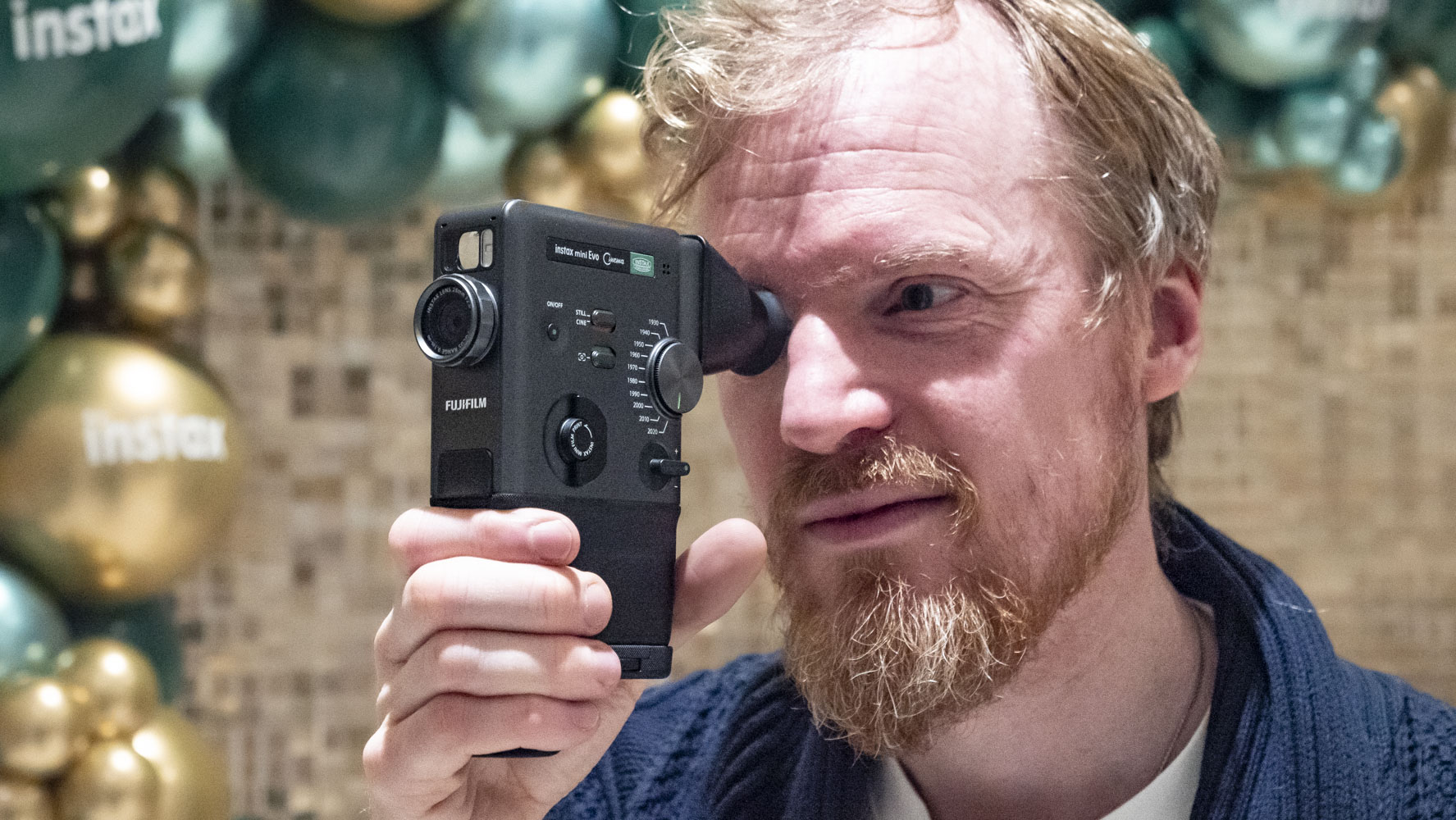 Photographer holding the Fujifilm Instax Mini Evo Cinema camera up to their eye
