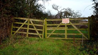 Private land sign on wooden gate