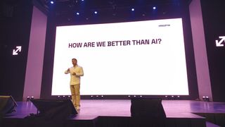 Joaqu&iacute;n Cuenca Abela of Freepik speaking at a conference in front of a slide reading "How are we better than AI?"