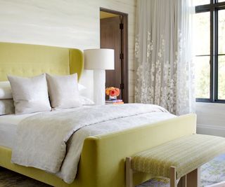 bedroom with mustard upholstery and sheer drapery