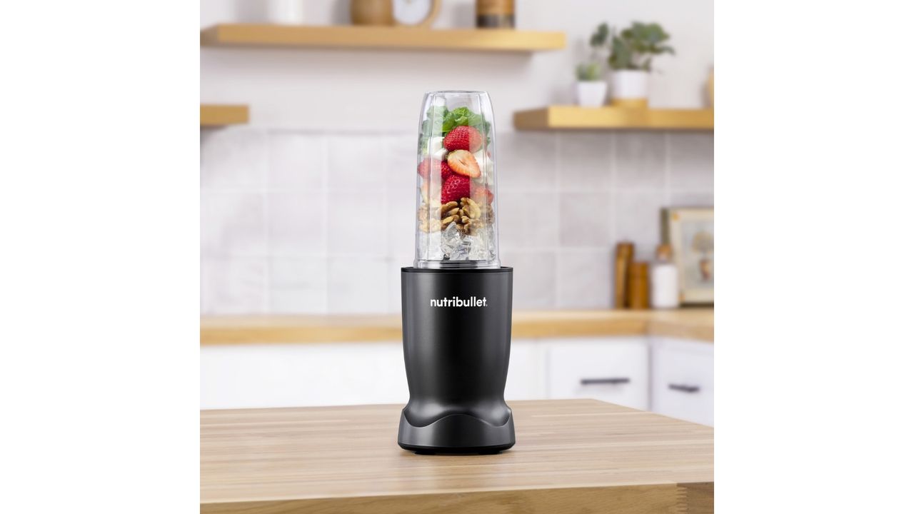Nutribullet Turbo blender filled with fresh fruit and other ingredients, styled on a kitchen worktop