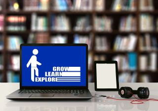 a laptop with the words explore, learn and grow on it. 