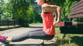 Woman doing triceps dips in a park