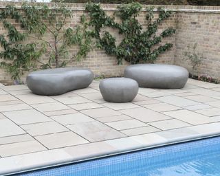 large pebble seats on deck by pool