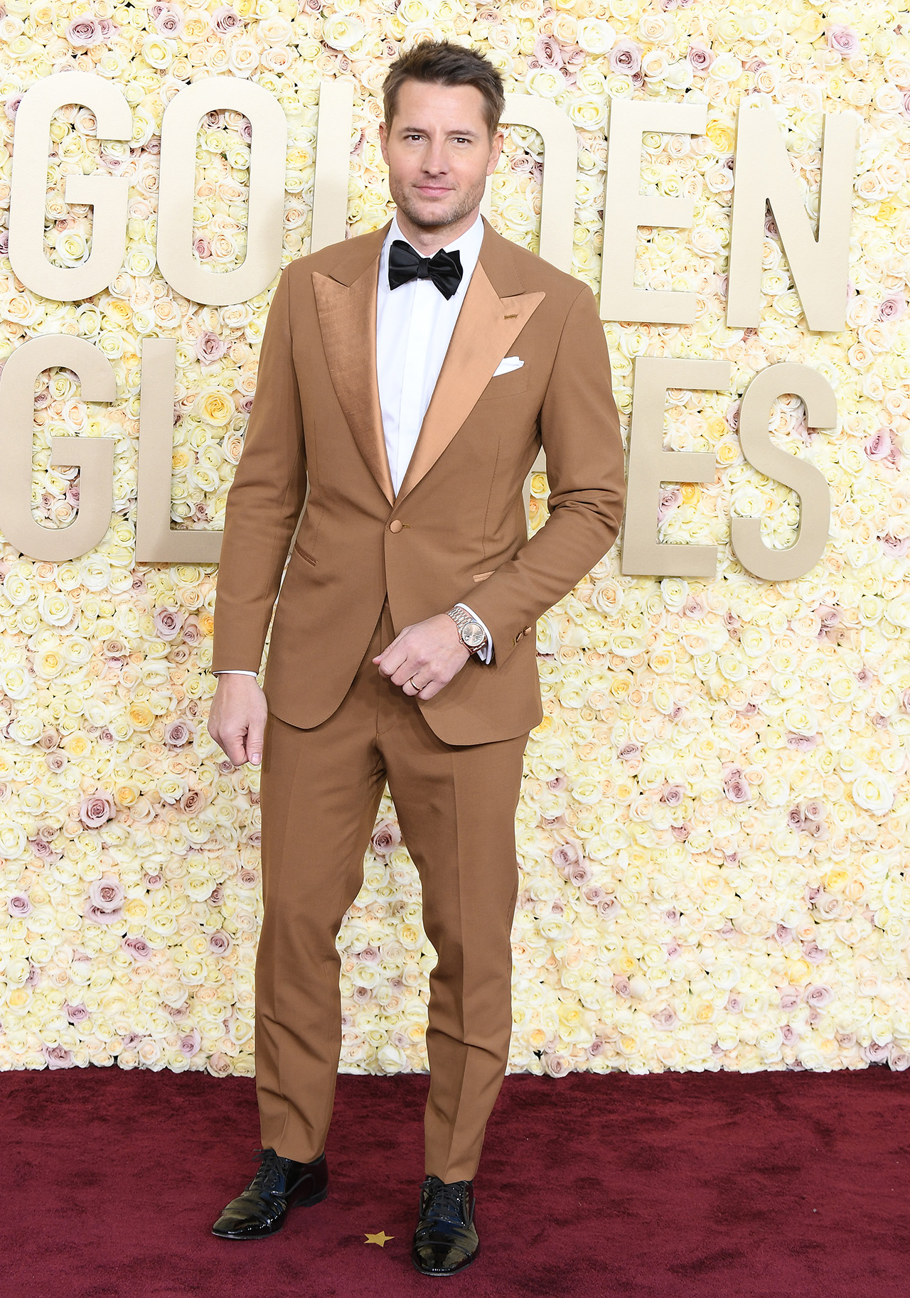 Justin Hartley in tan suit and black bowtie at Golden Globes event in which he was mistaken for Glen Powell.