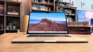 The 2024 MacBook Air M3 on a wooden table in front of a bookshelf.