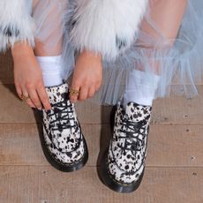 Woman wearing cow-print Dr Martens shoes
