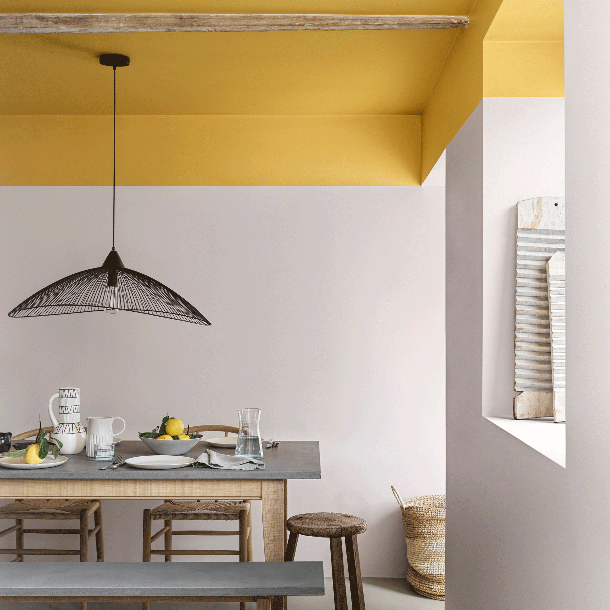 Dining room with yellow ceiling and black pendant light