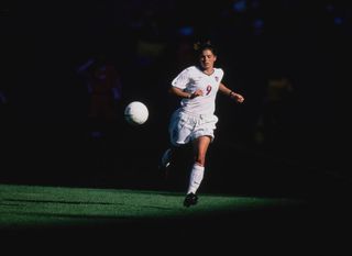 Mia Hamm #9, Forward for the United States in motion with the football during the FIFA Women's International friendly game against the Peoples Republic of China on 25th April 1999 at the Giants Stadium in East Rutherford, New Jersey, United States. The China won the game 2-1.