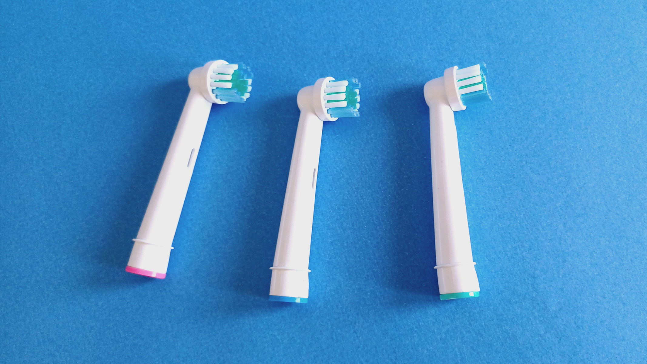 Three rotating brush heads on a blue background