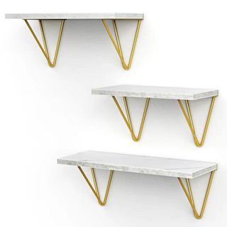 Three different sized floating shelves in marble, with gold metalwork