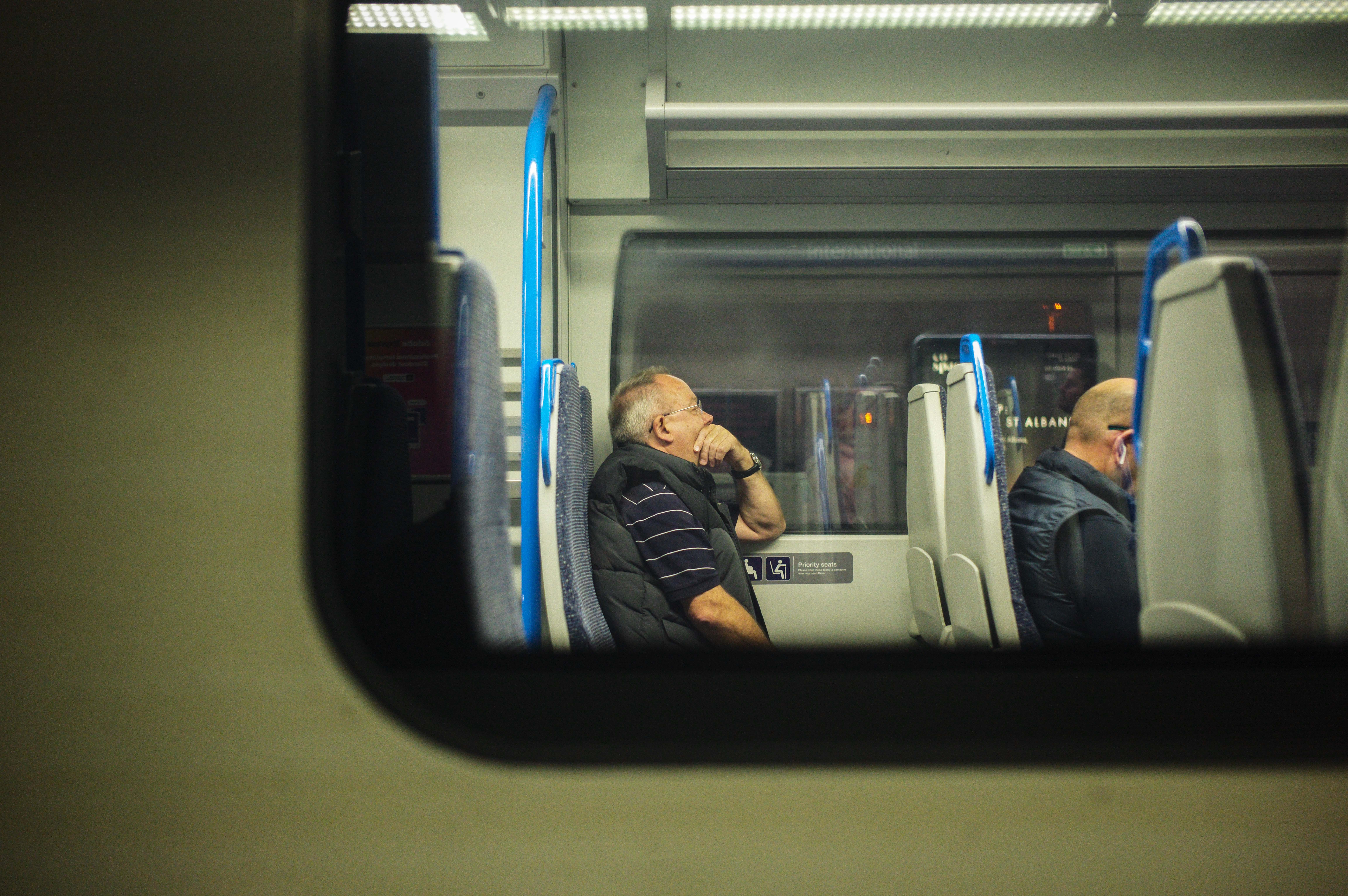 Man sitting looking out of the window on a train