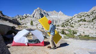 A camper putting the Therm-a-Rest NeoAir XLite NXT in his tent