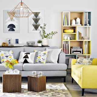 living room with geometric artwork and grey sofa