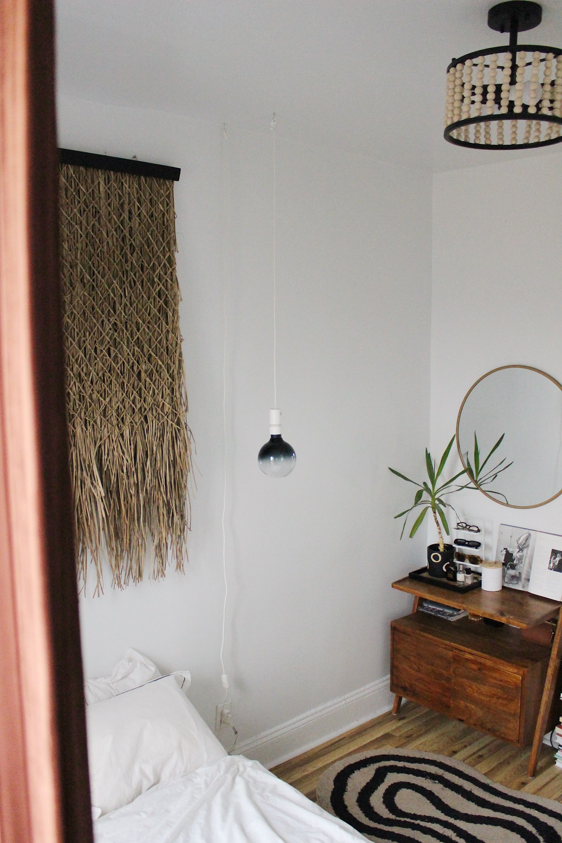 Kamar tidur dengan cermin dan karya seni gantung serta lampu