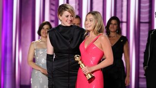 Greta Gerwig and Margot Robbie on stage at the Golden Globe awards accepting their win for Barbie
